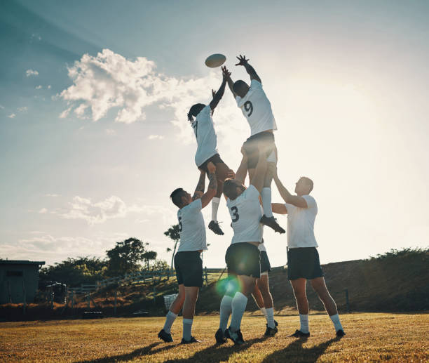 projectile complet de longueur de deux jeunes joueurs de rugby beaux attrapant le ballon pendant un lineout sur le terrain - équipe sportive photos et images de collection