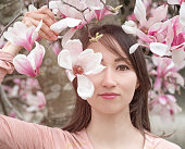 マグノリアの花を持つ日本庭園の女性