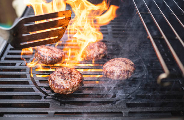 Hamburgers cooking on the BBQ Flamed grilled hamburgers cooking on a barbeque grilled stock pictures, royalty-free photos & images