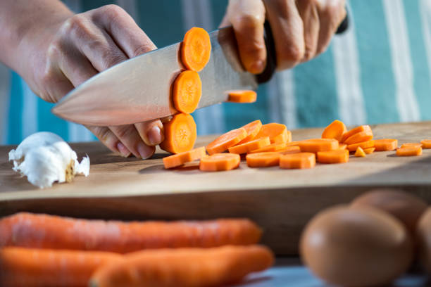 istock Woman cutting carrot on chopping board 1313617113