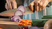 Woman cutting onion on chopping board