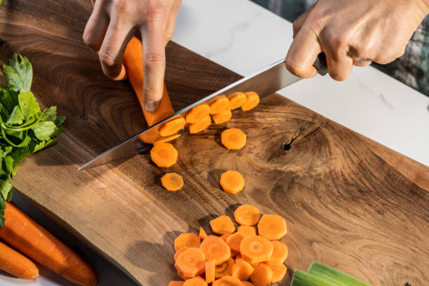 istock Woman cutting carrot on chopping board 1313617373