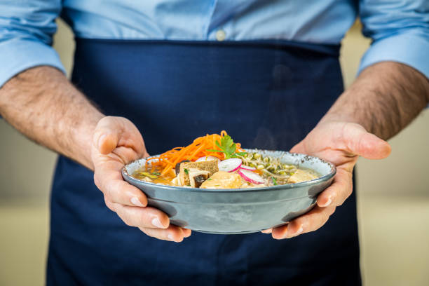 istock Man holding vegetarian ramen soup 1313617400