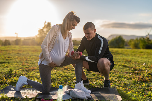 Trainer with one pregnant woman outdoors