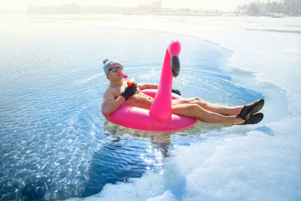 un hombre nadando en un agujero de hielo en invierno en finlandia, - man made ice fotografías e imágenes de stock