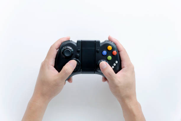istock A Black game joystick console controller in gamer hands.Game controller in hand isolated on white background. 1313619980