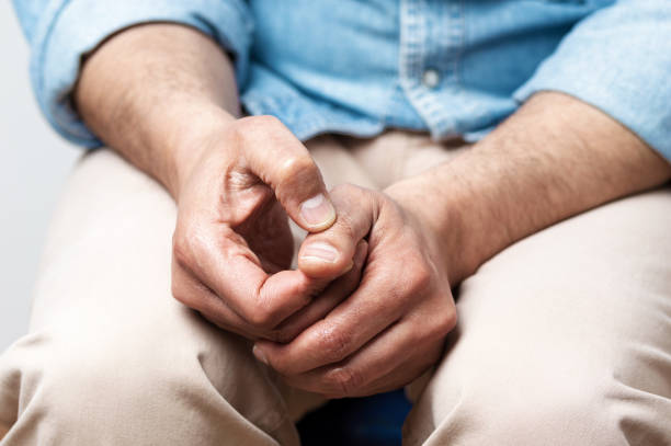 man sitting on a sofa and feeling anxious Cropped shot of a man sitting on a sofa and feeling anxious men hands stock pictures, royalty-free photos & images