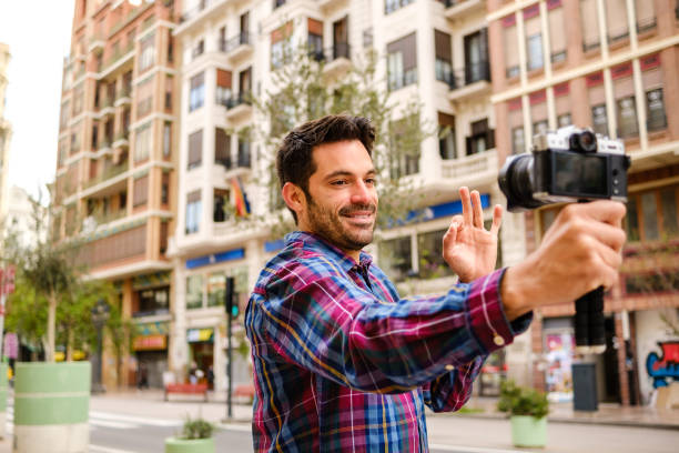 istock Man records a video with a camera in a city 1313624522