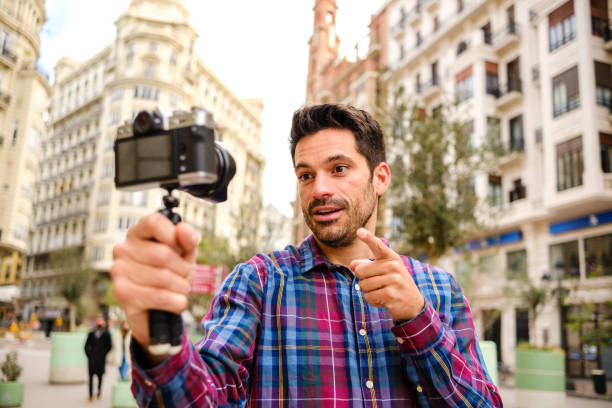 istock Man records a video with a camera in a city 1313624525