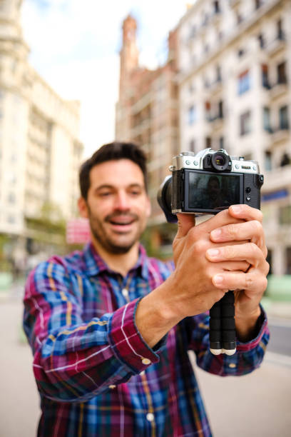 istock Man records a video with a camera in a city 1313624531