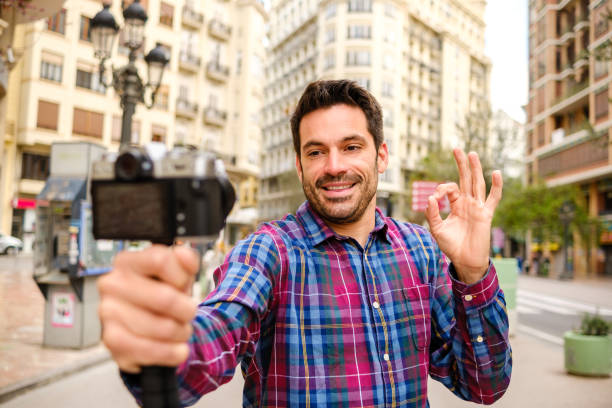 istock Man records a video with a camera in a city 1313624542