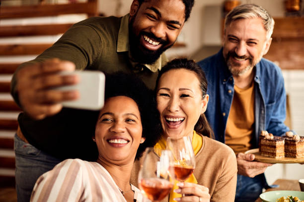 istock Multi-ethnic group of cheerful friends having fun while taking selfie with smart phone. 1313625770