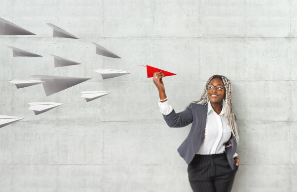 young beautiful african woman holding hand model paper air plane. design of travel concept with air plane on empty gray color background - way out sign imagens e fotografias de stock