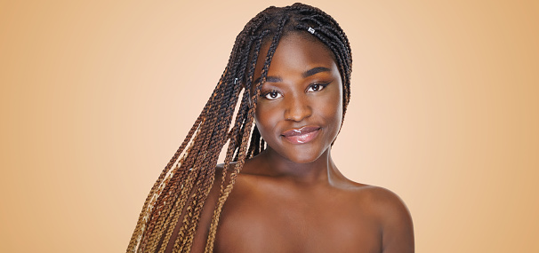 Beauty portrait of african american girl with clean healthy skin on beige background. Smiling dreamy beautiful black woman