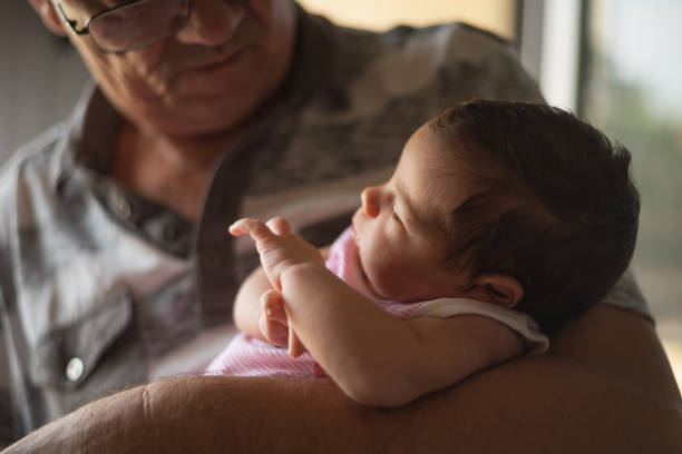 Grandfather is embracing newborn baby.