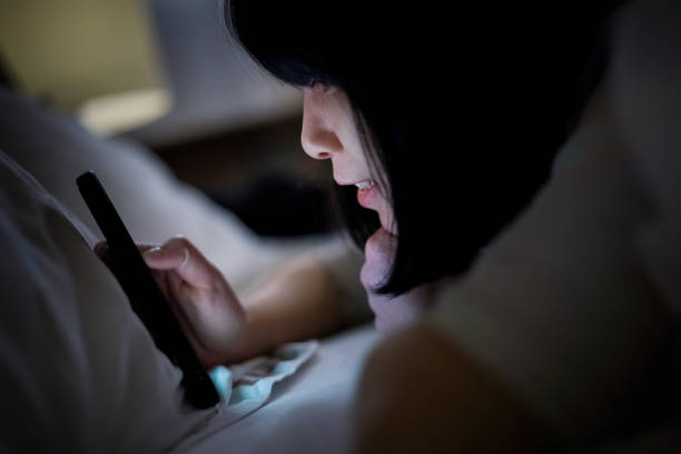 istock Young woman lying in bed using a smartphone 1313629537