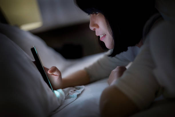 istock Young woman lying in bed using a smartphone 1313629545