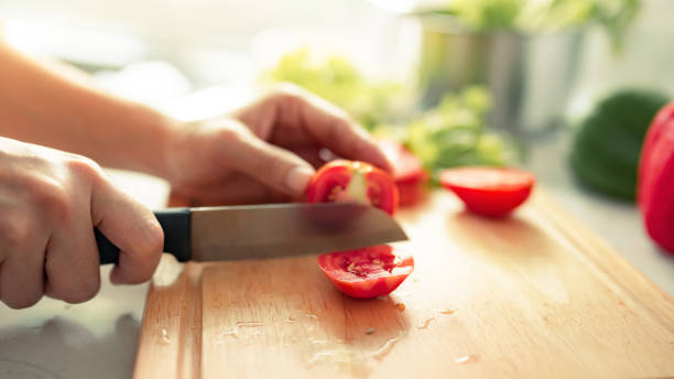 istock Human hands cooking in kitchen. Woman slicing tomato. 1313631686