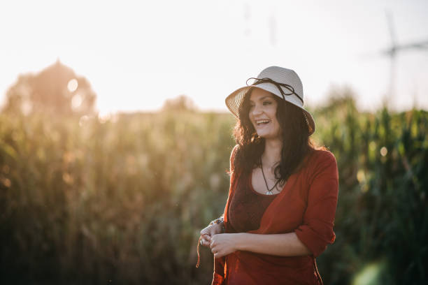 Pretty young country woman laughing among nature in a sunset