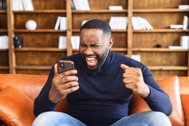 istock Excited black man looking at the phone and screaming 1313632093