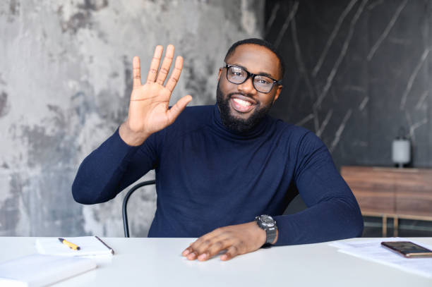 istock Young affable man sitting at the table welcoming 1313632193