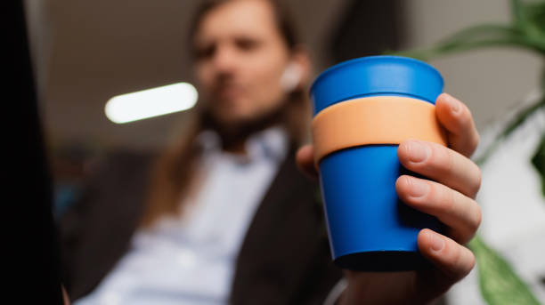 istock A man holding reusable blue cup, and drinking coffee 1313632346