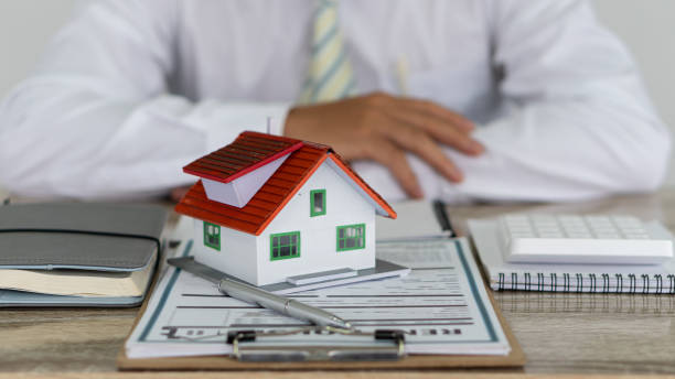 istock House type real estate agent and calculator with contract documents on the table in the office. 1313633100
