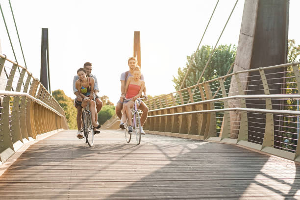 istock Young friends having fun riding bicycles outdoor on bridge park - Focus on front faces 1313634749
