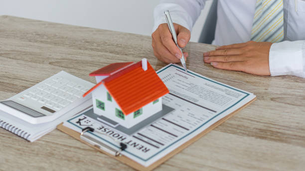 istock House type real estate agent and calculator with contract documents on the table in the office. 1313635549