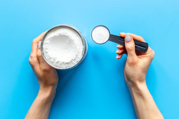istock Hands holding scoop with whey protein. Sport nutrition 1313635907