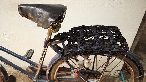 Old bicycle, black seat through a long time use.