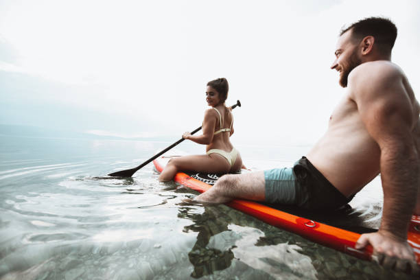 istock Romantic Paddleboarding By Cute Couple On Lake 1313637333