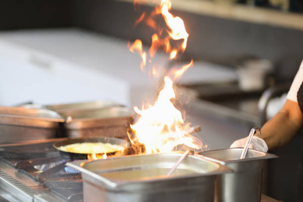 istock Chef cooking with flame on kitchen stove closeup 1313638097