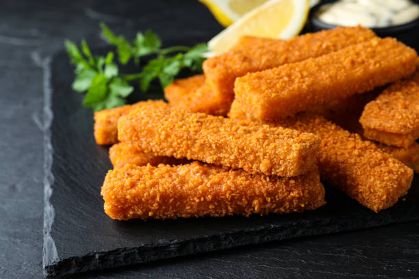 istock Fresh breaded fish fingers served on black table, closeup 1313638444