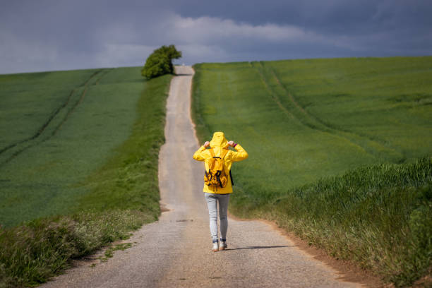 istock Lone woman walking on empty road 1313639771