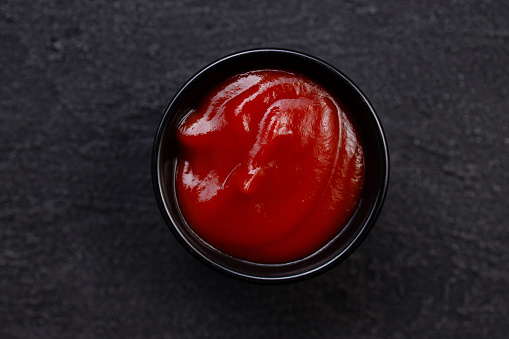 Tomato barbeque sauce dip in bowl, close up. Condiment for tasty food, ketchup, delicious homemade seasoning for meat and vegetables