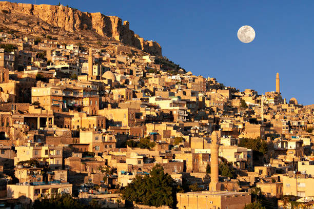 View over the historical city of Mardin with the full moon in the sky, Turkey