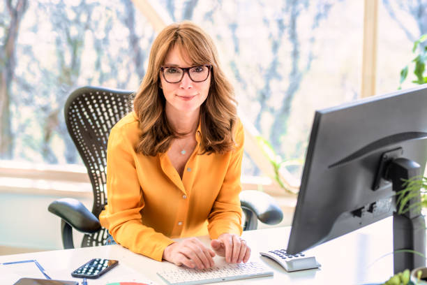 istock Middle aged businesswoman sitting behind her computer while working from home 1313642858