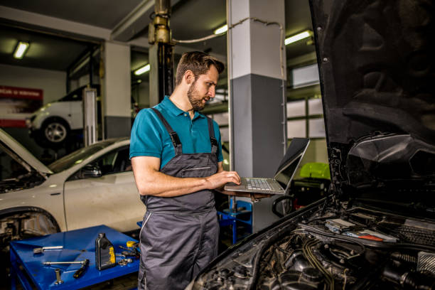 istock Mechanic using laptop in car repair shop. 1313642894