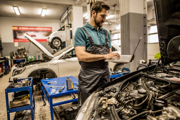 istock Mechanic using laptop in car repair shop. 1313642930