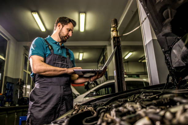 istock Mechanic using laptop in car repair shop. 1313643089
