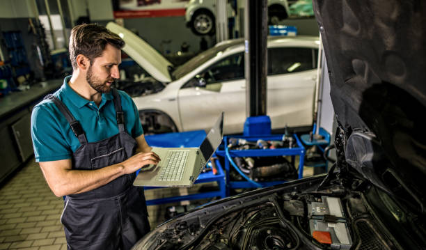 istock Mechanic using laptop in car repair shop. 1313643140