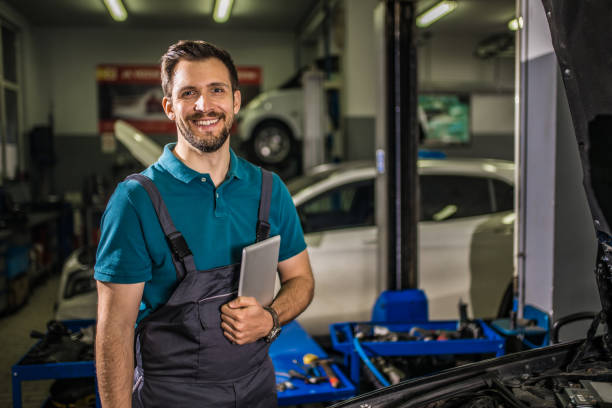 istock Happy mechanic looking at camera while at work in auto repair shop. 1313643153