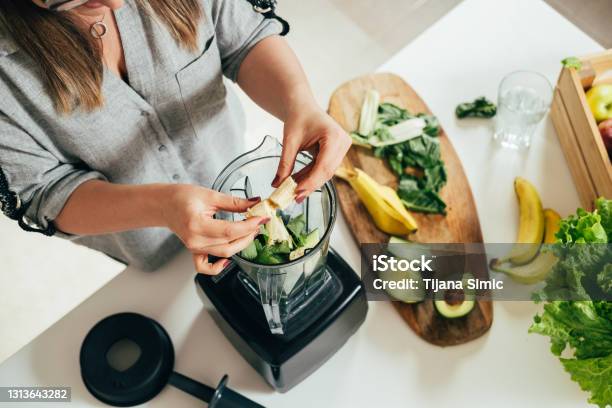 Woman Is Preparing A Healthy Detox Drink In A Blender A Green Smoothie With Fresh Fruits Green Spinach And Avocado Stock Photo - Download Image Now