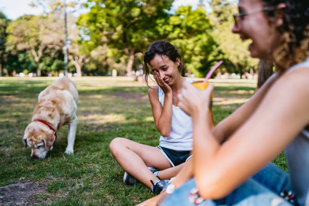 istock Two women and dog relaxing in park 1313644220