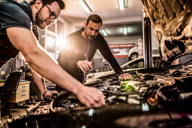 istock Two auto mechanics repairing car's engine. 1313645999