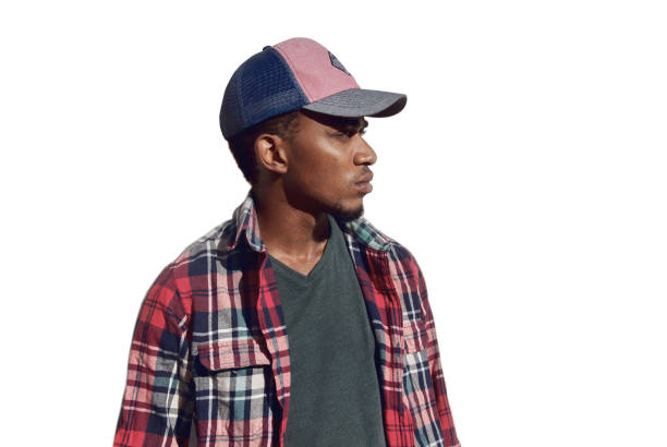 Portrait of young african man looking away wearing a baseball cap, red plaid shirt isolated on a white background stock photo