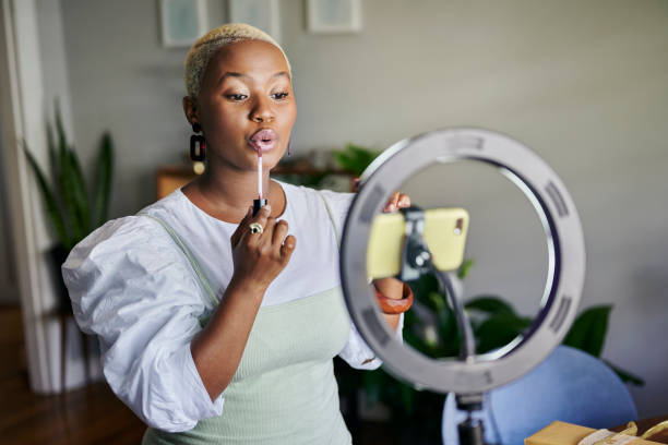 istock Young African influencer putting on lip gloss during a vlog post 1313649289