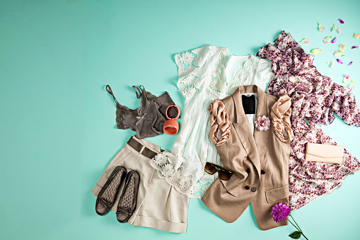 Women's clothing with personal accessories on turquoise colored background