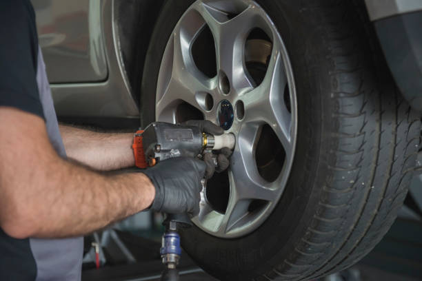 istock car mechanic screwing a car wheel 1313652338